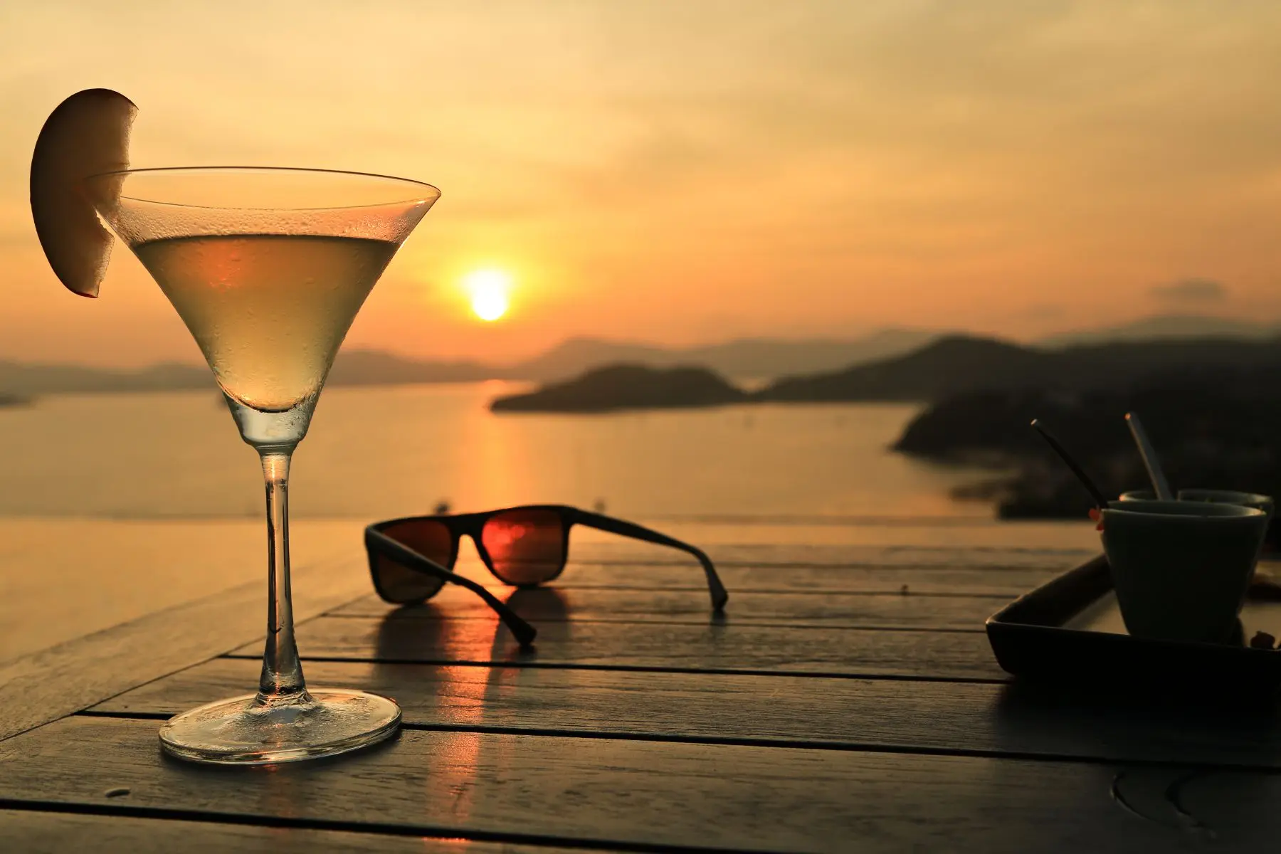 Cocktail with the sunset view over sea and island